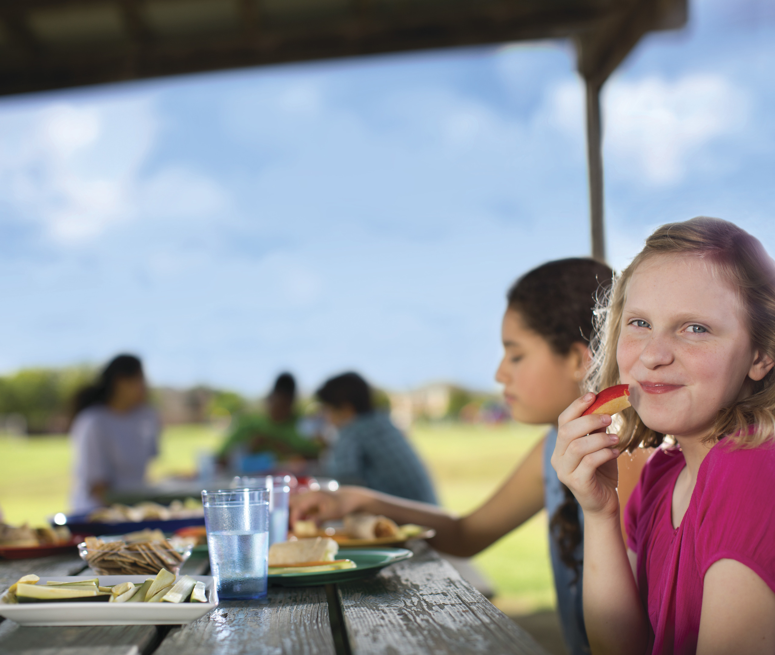 Young girl eating an apply slice in promotion of of the Nutrition Programs at the YMCA of Greater Kansas City
