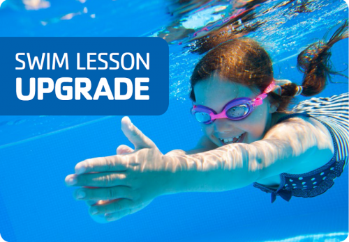 Young girl swimming under water with goggles on.