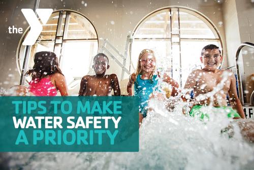 Four kids sitting on the ledge of an indoor pool while kicking their feet to create a splash.
