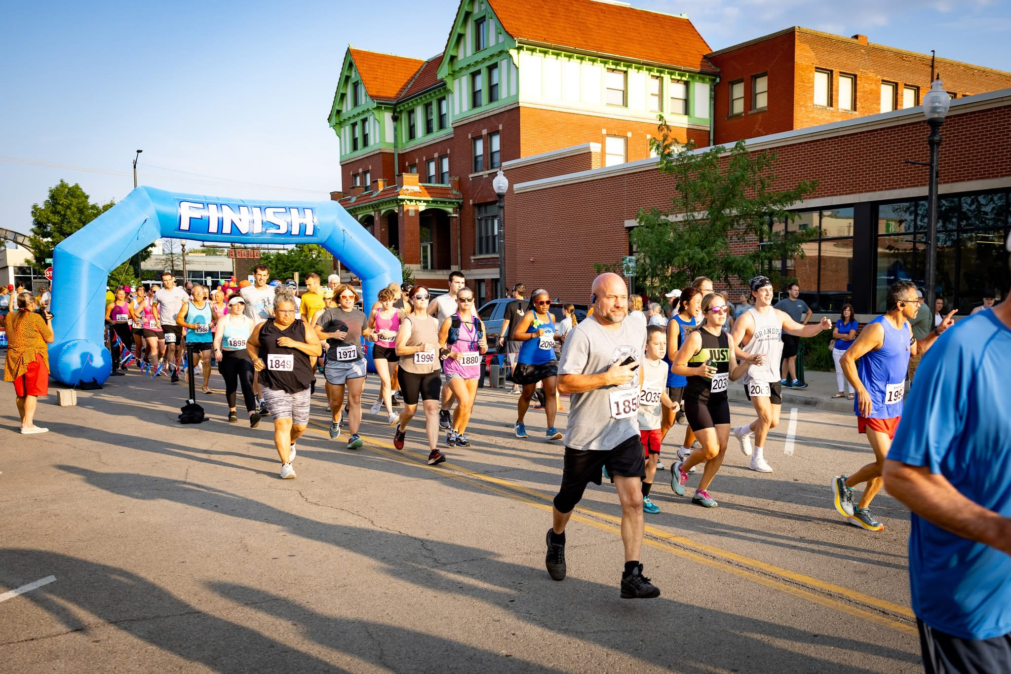 Runners cross the finish line of the Amelia Earhart Run in front of the Atchison Family YMCA/Cray Community Center