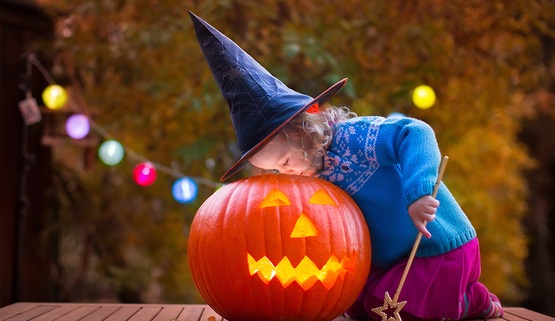 Young girl looks inside jackolantern