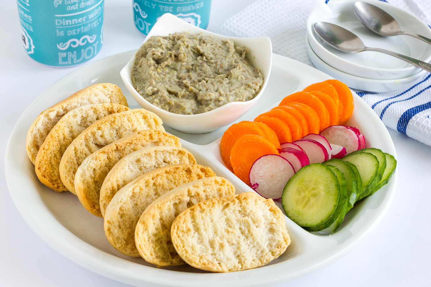 Party platter of healthy snacks including vibrant veggies, whole grain crackers, and hummus.
